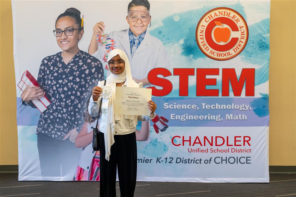 A photo of a student with her Science Fair award.